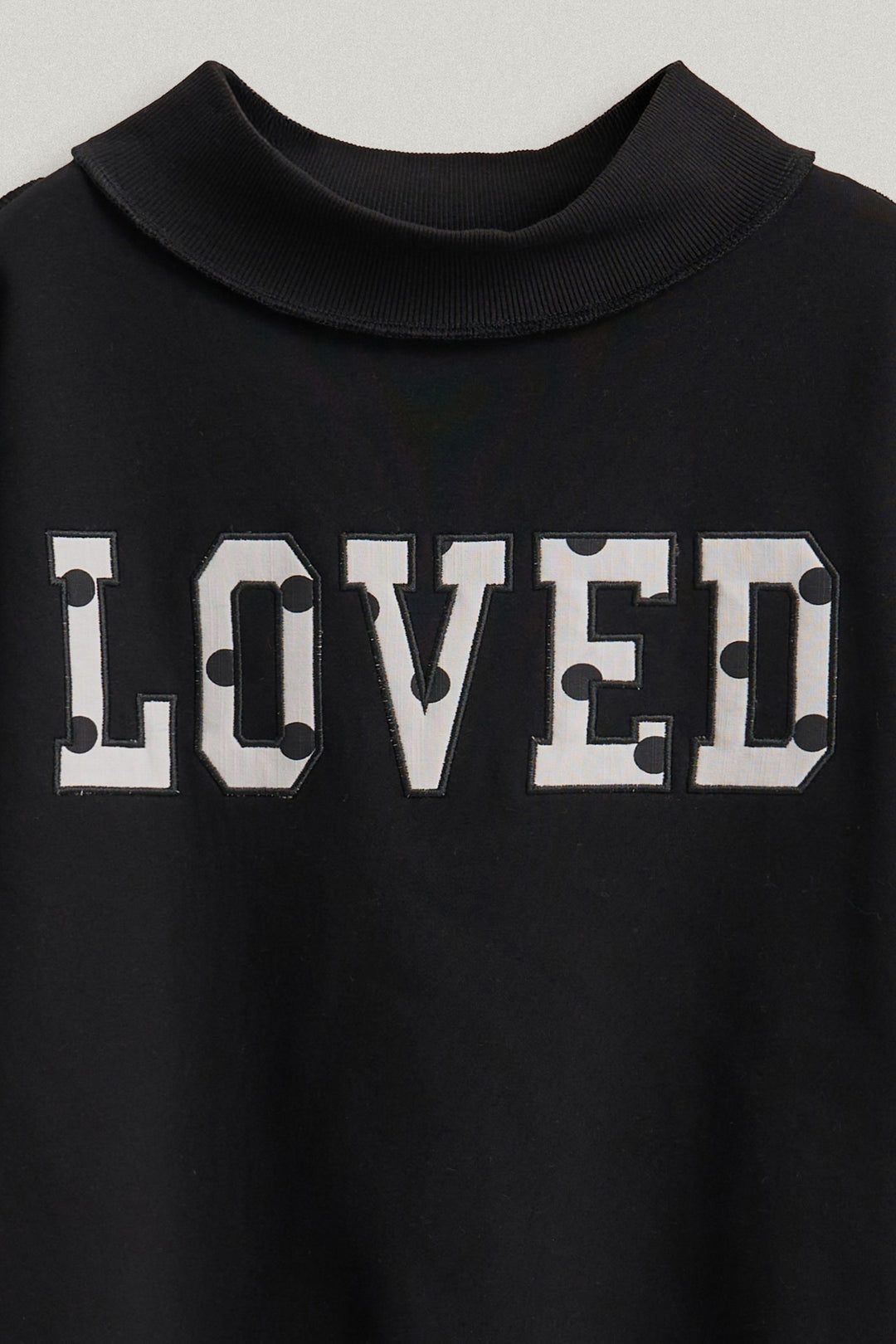 LOVED Varsity Patch Mock Neck Sweatshirt with Exposed Seams in Black - Women's Wholesale Shorts | Trend Notes